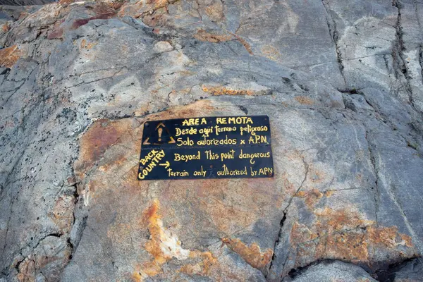 stock image Warning sign in the wild region in Patagonia to warn individual trekkers: only with local guides to enter the risky area