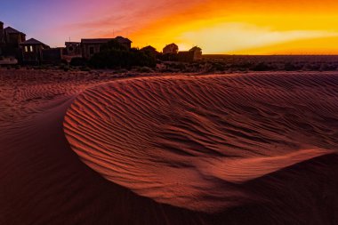 Small sand dune during sunset time at the site of abandoned Kolmanskoppe  - a ruin diamond mining settlement from the early German colony clipart