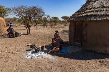 Damaraland, Namibya - 14 Temmuz: Bir Himba kabilesi köyünde kadınlar sohbet edip yemek pişiriyor. Himba halkı Kuzey Namibya 'da yaşayan yerli bir kabiledir.