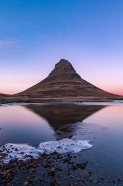 İzlanda 'da sonbahar mevsiminde gün batımında yansıması olan ünlü Kirkjufell Dağı.