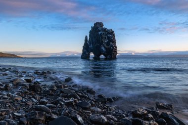 The rock formation Hvisterkur, also called Rhino, in the sunrise morning with reflection on black sand beach. clipart