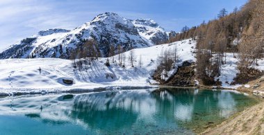 İsviçre Alpleri dağlık gölü Lac Bleu kışın karlı dağ yansıması ile