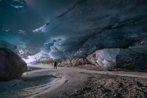 Morteratsch, Switezrland - 27 Mart 2025: Buzulun tam altında, güvenlik kaskında yürüyüş yapan Morteratsch Buzulu, İsviçre