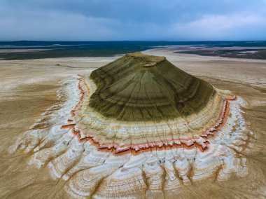 Boszhira kireçtaşıyla ön planda bir koç kafatası gün doğumunda arka planda zirve yapıyor.