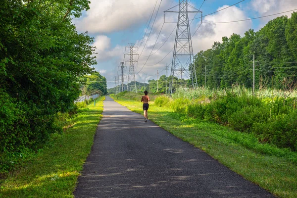 A man runs shirtless on a Summer day on the henry Hudson Trail in Monmouth County, New Jersey.