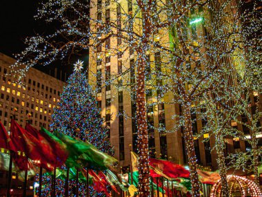 Tatil bayrakları ve Noel ağacı New York 'taki Rockefeller Center' da rüzgarlı bir gecede.