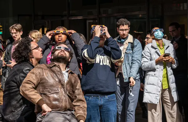 ニューヨーク April 4月8日 マンハッタンのダウンタウンで太陽の日食を見ているニューヨーカー ロイヤリティフリーのストック画像