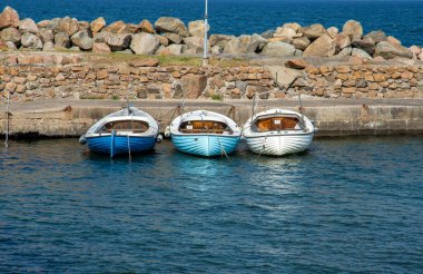 İsveç 'in güneyinde taş iskelesi olan üç tekne var.