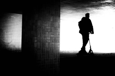 Sanatsal olarak bulanık hareketle scooter süren bir adamın silüetinin bulanık görüntüsü..