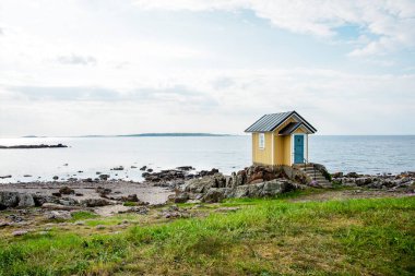 İsveç 'in güneyinde deniz kenarında küçük sarı bir kulübe..
