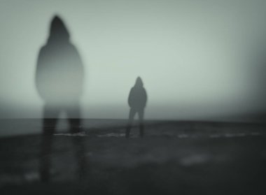 Silüet içinde bir insanın deniz kenarında başka bir insanı izlediği gerçeküstü bir görüntü.