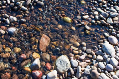 Sığ sularda taşların renkleri farklı
