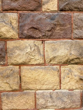 Sıcak sarı ve kırmızı renkli antik tuğla duvara yakın çekim.