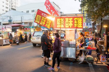 Chiayi, Tayvan - 6 Aralık 2022: Chiayi, Tayvan 'daki Wenhua yol gece pazarında insanlar ve tezgahlar. Her çeşit yerel atıştırmalığın ve lezzetin örneklenebildiği bir yayadır.