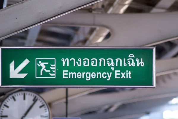 Large Emergency Exit sign with green light box is placed on BTS station platform.