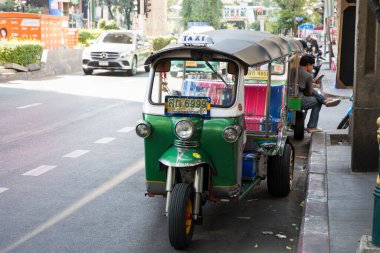 Bangkok, Thailand- 13 Feb, 2023: Traditional tuk-tuk on the road in Bangkok. Tuk tuks are motorized 3-wheeled rickshaws that ferry passengers around clipart