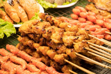 Street food market with grilled skewers food. BBQ chicken butt