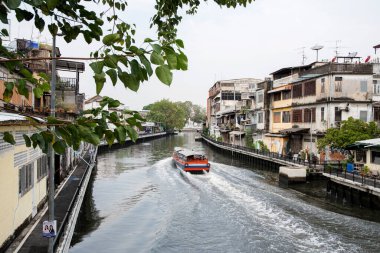 Bangkok, Thailand- 17 Feb, 2023: River taxi travels along the Bangkok canal to ferry passengers. Boats and ferries are a convenient and interesting way to get around Bangkok