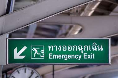 Large Emergency Exit sign with green light box is placed on BTS station platform.