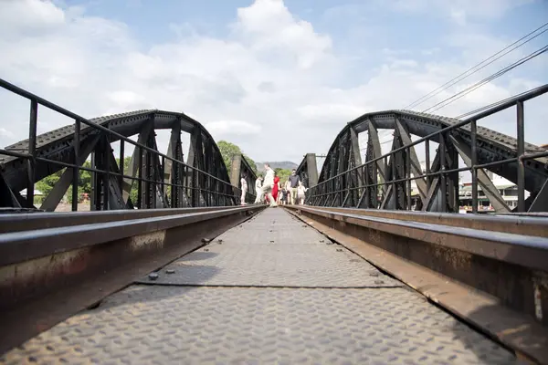 Kanchanaburi, Tayland - 16 Şubat 2023: Turistler Kanchanaburi, Tayland 'daki Kwai Köprüsü veya Ölüm Köprüsü' nde yürüyorlar. 2. Dünya Savaşı sırasında Japonlar tarafından inşa edilen metre ölçümlü demiryolunun bir parçasıydı.