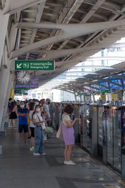 Bangkok, Tayland - 15 Şubat 2023: Bangkok 'taki BTS istasyonunda treni bekleyen yolcular. BTS Skytrain Bangkok 'ta önemli bir ulaşım modudur. 