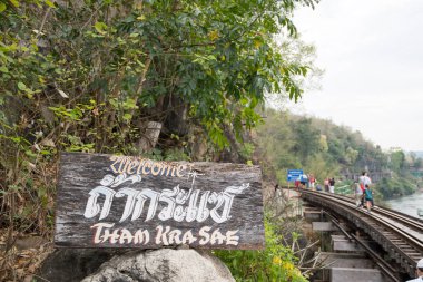 Kanchanaburi, Tayland - 16 Şubat 2023: Turistler Tham Krasae Demiryolu Köprüsü boyunca yürüyorlar, Kanchanaburi. 1943 baharında sadece 17 günlük İkinci Dünya Savaşı sırasında inşa edildi..