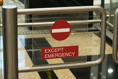 Kırmızı kapılı metal kapı. Giriş işareti yok. Acil durum dışında.