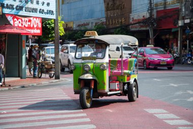 Bangkok, Tayland - 14 Şubat 2023: geleneksel Tuk-tuk seyahatleri Bangkok 'ta. Tuk tuk 'lar, yolcuları taşıyan 3 tekerlekli triportörlerdir.
