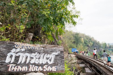 Kanchanaburi, Tayland - 16 Şubat 2023: Turistler Tham Krasae Demiryolu Köprüsü boyunca yürüyorlar, Kanchanaburi. 1943 baharında sadece 17 günlük İkinci Dünya Savaşı sırasında inşa edildi..