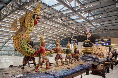 Bangkok, Tayland - 18 Şubat 2023: Suvanabhumi Havalimanı 'ndaki gümrüksüz bölgede Süt Okyanusu heykelinin çalkalanması Yaksha Sahnesi