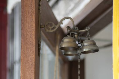 Kahverengi ahşap kapıda eski bakır çan.