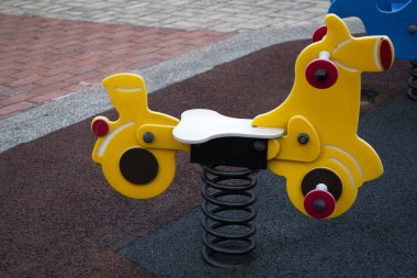 Oyun parkında metal yay üzerinde sallanan sandalye