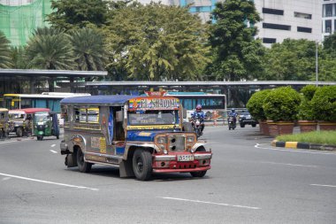 Manila, Filipinler-15 Ekim 2023: Jeepney taksisi Manila şehir merkezinde yolda ilerliyor. Jipler, minibüs benzeri kamu araçlarıdır.