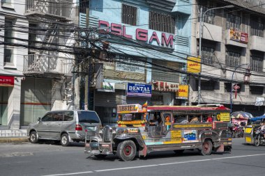 Manila, Filipinler-15 Ekim 2023: Jeepney taksisi Manila şehir merkezinde yolda ilerliyor. Jipler, minibüs benzeri kamu araçlarıdır.