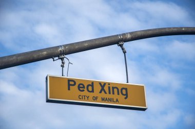 Manila, Filipinler- 13 Ekim 2023: Ped Xing tabelası mavi gökyüzü ile caddede. Ped Xing tabelaları, gelen sürücülere yaya geçidini ya da insanların yolu geçtiği alanı bildirmek için yapılır..