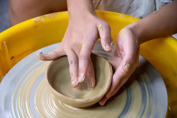 Females ceramics maker working with pottery wheel