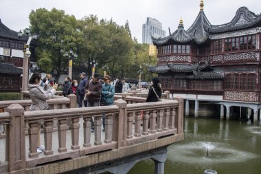 Şangay, Çin - 4 Aralık 2023: İnsanlar Yuyuan 'daki Jiuqu köprüsünde yürüyor. Meşhur Yu Garden 'a giden küçük bir gölün üzerindeki ayak köprüsü..