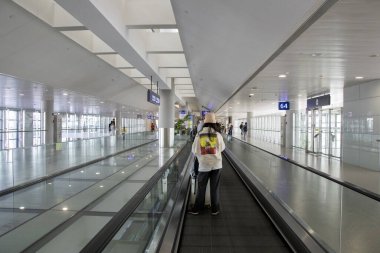 Şangay, Çin - 27 Kasım 2023: İnsanlar Şangay Pudong Havaalanı 'ndaki göçmen bölgesine doğru hareket ediyor. Pudong Havaalanı, Çin 'in büyük bir havacılık merkezidir.