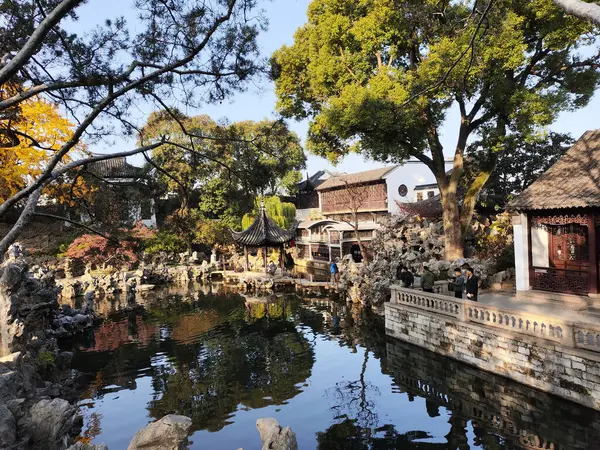 Suzhou, Çin - 7 Aralık 2023: Çin 'in Suzhou kentindeki Lion Grove Garden' daki kaya ve göl üzerindeki sonbahar manzarası. Diğer klasik Suzhou bahçeleri UNESCO olarak tanınır.