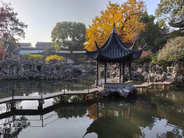 Suzhou, Çin - 7 Aralık 2023: Çin 'in Suzhou kentindeki Lion Grove Garden' daki kaya ve göl üzerindeki sonbahar manzarası. Diğer klasik Suzhou bahçeleri UNESCO olarak tanınır.