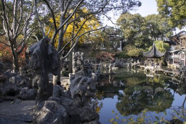 Suzhou, Çin - 7 Aralık 2023: Çin 'in Suzhou kentindeki Lion Grove Garden' daki kaya ve göl üzerindeki sonbahar manzarası. Diğer klasik Suzhou bahçelerinde UNESCO Dünya Mirası olarak tanınır..