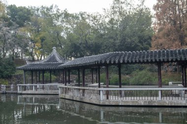 Suzhou, Çin - 6 Aralık 2023: Çin 'in Suzhou kentindeki Dongyuan parkında sonbahar sahnesi. Bu, antik şehir duvarının, şehir içi nehrin ve güzel manzaranın ahenkli bir birleşimi..