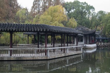 Suzhou, Çin - 6 Aralık 2023: Çin 'in Suzhou kentindeki Dongyuan parkında sonbahar sahnesi. Bu, antik şehir duvarının, şehir içi nehrin ve güzel manzaranın ahenkli bir birleşimi..