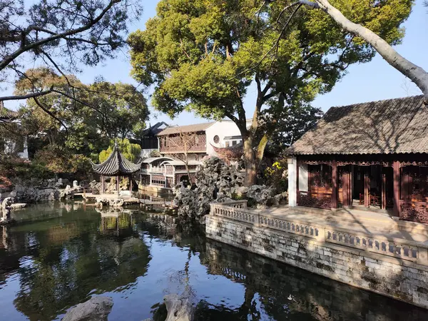 Suzhou, Çin - 7 Aralık 2023: Çin 'in Suzhou kentindeki Lion Grove Garden' daki kaya ve göl üzerindeki sonbahar manzarası. Diğer klasik Suzhou bahçeleri UNESCO olarak tanınır.