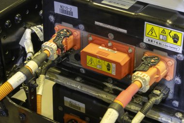 Singapur-12 Ocak 2024: Turuncu renkli elektrik aracı için güç kaynağı bağlantısı ve kablo.