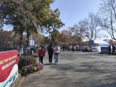 Nanjing, Çin - 2 Aralık 2023: İnsanlar sonbahar döneminde Nanjing 'deki Xuanwu Gölü' nü ziyaret ediyor. Xuanwu Gölü, Çin tarafından korunan güzel manzaralı bir yerdir.