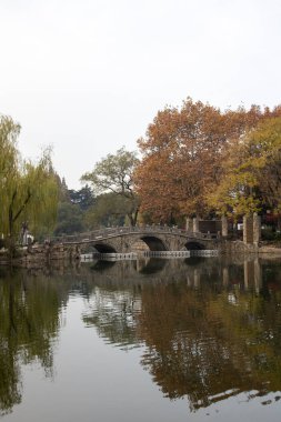 Suzhou, Çin - 6 Aralık 2023: Çin 'in Suzhou kentindeki Dongyuan parkında sonbahar sahnesi. Bu, antik şehir duvarının, şehir içi nehrin ve güzel manzaranın ahenkli bir birleşimi..