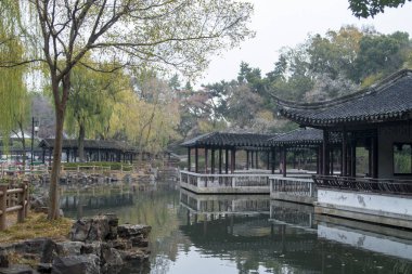 Suzhou, Çin - 6 Aralık 2023: Çin 'in Suzhou kentindeki Dongyuan parkında sonbahar sahnesi. Bu, antik şehir duvarının, şehir içi nehrin ve güzel manzaranın ahenkli bir birleşimi..