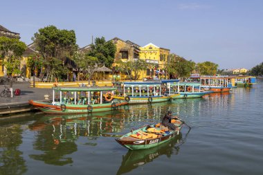 Hoi An, Vietnam- 29 Şubat 2024: Hoi An, Vietnam 'da antik mimarinin önündeki geleneksel tekneler. Hoi An, karışık kültürler ve mimari ile ünlü Dünya Kültür Mirası sitesidir..