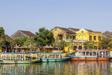 Hoi An, Vietnam- 29 Şubat 2024: Hoi An, Vietnam 'da antik mimarinin önündeki geleneksel tekneler. Hoi An, karışık kültürler ve mimari ile ünlü Dünya Kültür Mirası sitesidir..